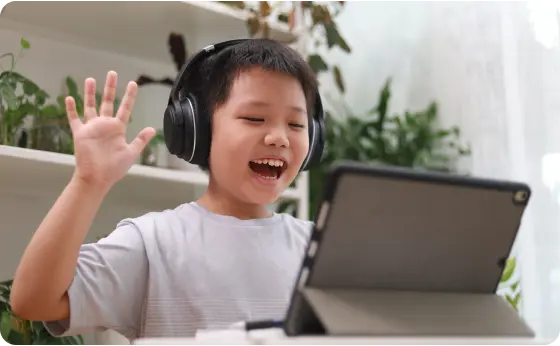 Estudiante de primaria asistiendo a una clase en línea con auriculares negros